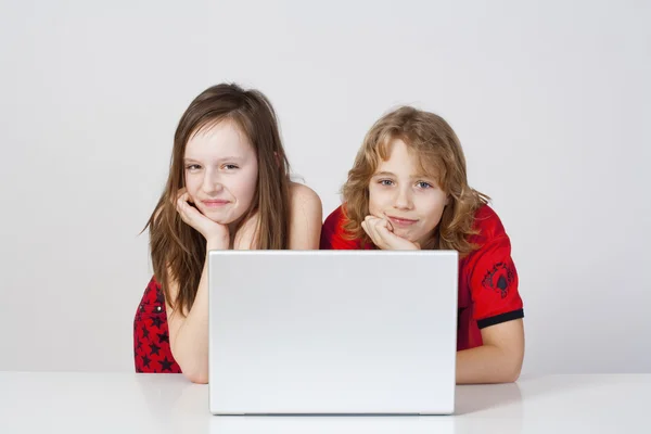 Jongen en meisje met laptop — Stockfoto