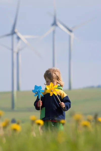 Fırıldak ve rüzgar çiftliği olan çocuk — Stok fotoğraf