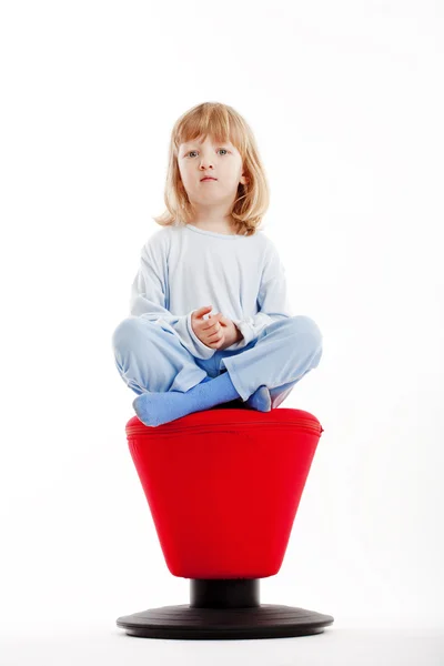 Menino sentado em fezes vermelhas — Fotografia de Stock