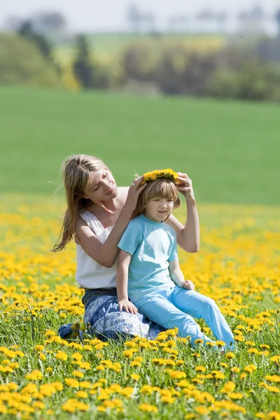 Mother and son in dandelion field — Stock Photo, Image