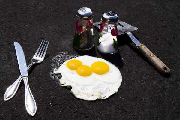 Concept - Fried Eggs on Sizzling Asphalt Driveway — Stock Photo, Image