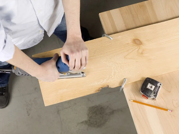 Snijden een stuk hout met behulp van puzzel — Stockfoto