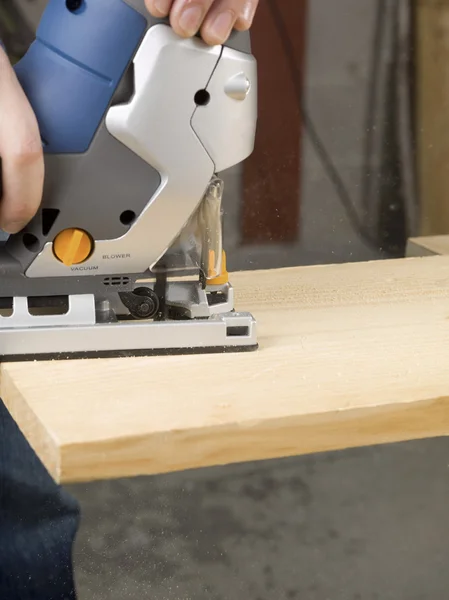 Persoon snijden houten plank met de Snijder van de puzzel — Stockfoto