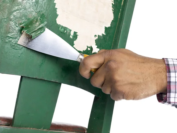 Pessoa removendo tinta da cadeira verde velha — Fotografia de Stock