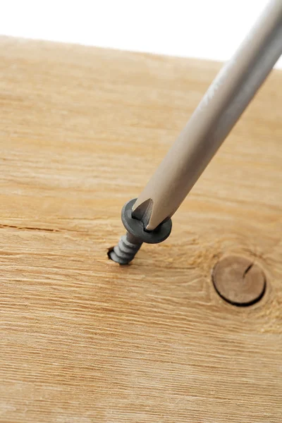 Schraube mit Schraubenzieher auf ein Holz getrieben — Stockfoto