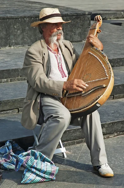 Colorful man in traditional dress playing the bandura — Stock Photo, Image