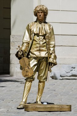 Living statue - the man in the image of the musician clipart