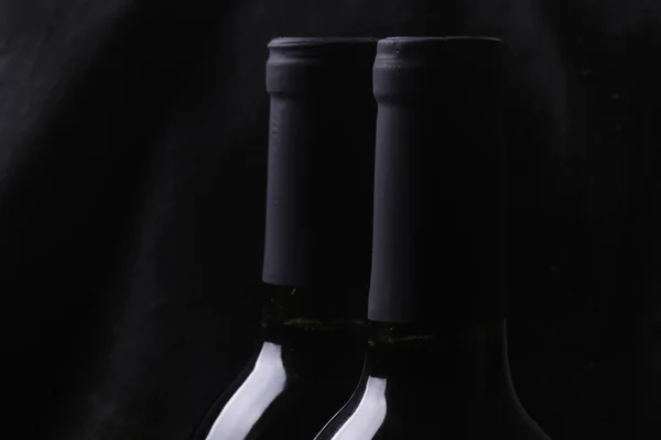 Flessen rode wijn op zwart Stockafbeelding