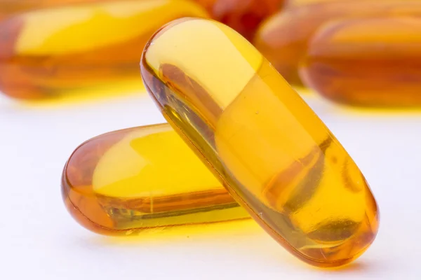 Žlutá pilulky vitaminu měkké gely - rybí tuk Stock Fotografie