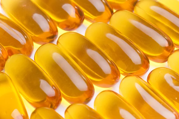 Žlutá pilulky vitaminu měkké gely - rybí tuk Stock Fotografie