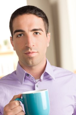 Cute guy with serious expression holding coffee mug clipart