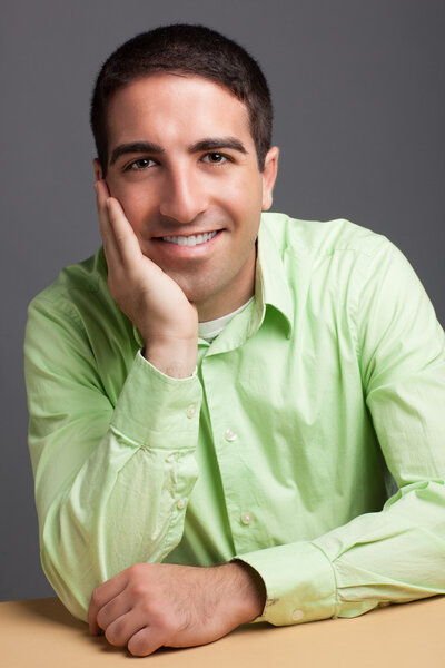 Мужчина, опираясь на руку, смотрит в камеру
