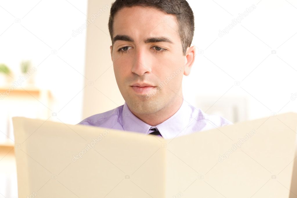 Serious man looking at beige folder