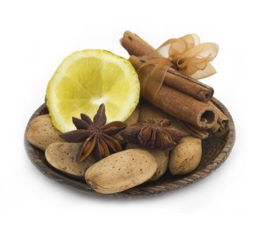 Beyaz üzerine izole edilmiş ahşap tabakta limonlu baharat ve fındık karışımı.