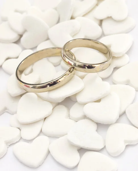 Anéis de casamento no fundo corações brancos — Fotografia de Stock