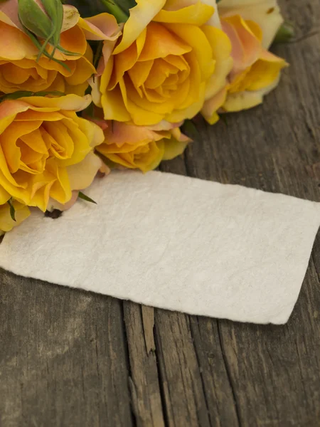 Blank note on the old table with yellow roses — Stock Photo, Image