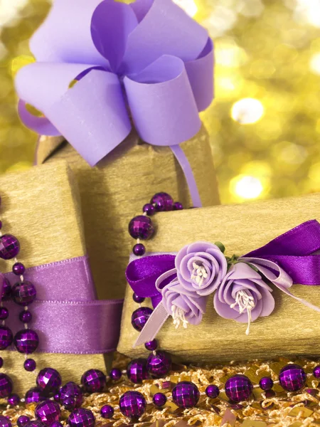 Golden gift boxes with beautiful purple decoration — Stock Photo, Image