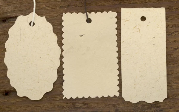 Three tags or labels on the wooden background — Stock Photo, Image