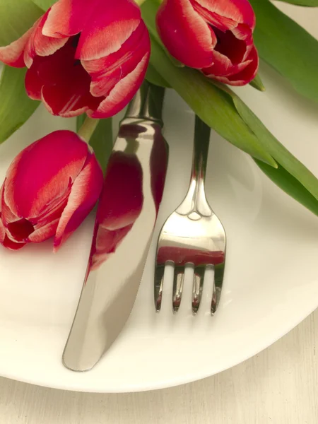 Vidlička a nůž s tulipány — Stock fotografie