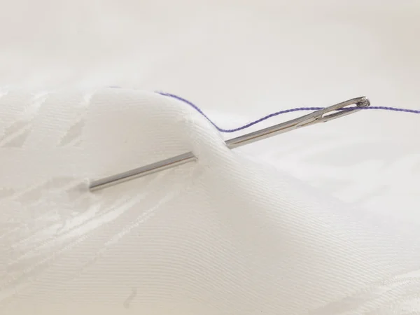 Needle in white sateen — Stock Photo, Image