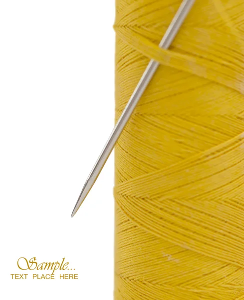 Needle in the yellow bobbin with the place for your text — Stock Photo, Image