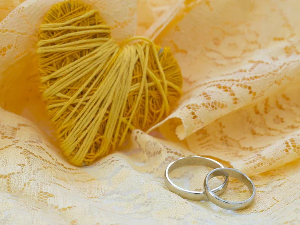 Žluté srdce a snubní prsteny — Stock fotografie