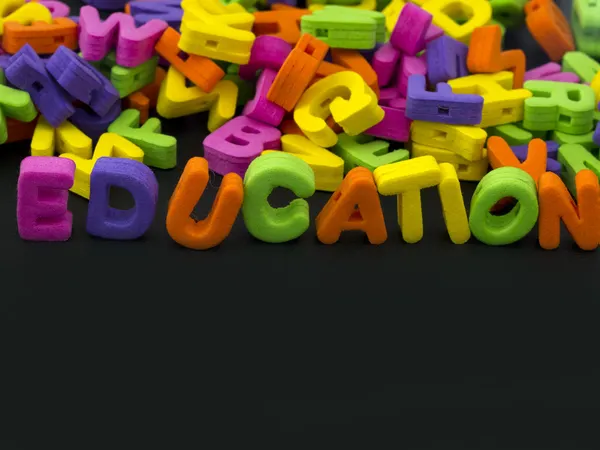 Education title written of rubber letters on the black background — Stock Photo, Image
