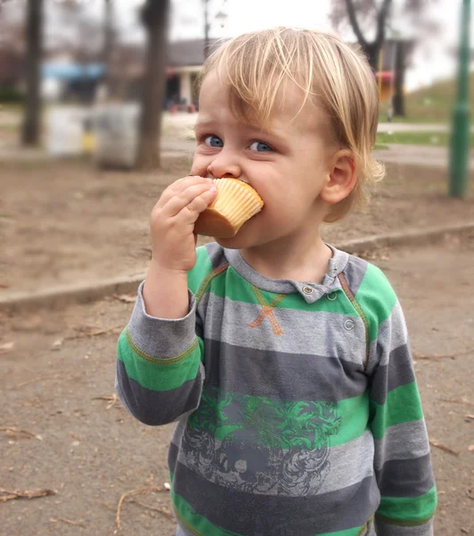 Een jongen eten muffin — Stok fotoğraf