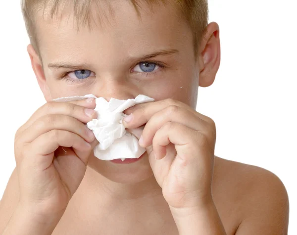 Sjuk pojke blåser näsan — Stockfoto