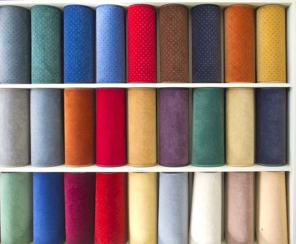 Разноцветные образцы ковров на полках — стоковое фото