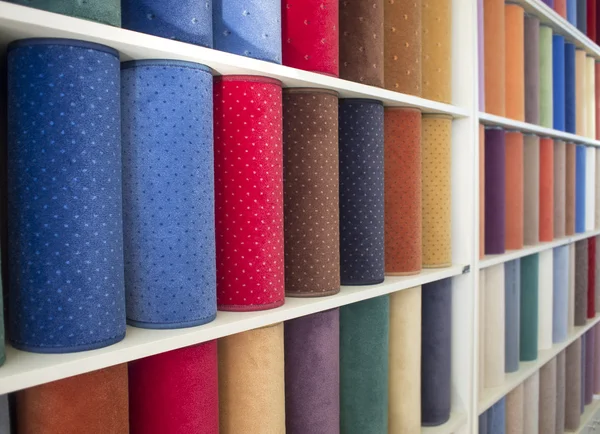 stock image Colorful carpets samples on the shelves