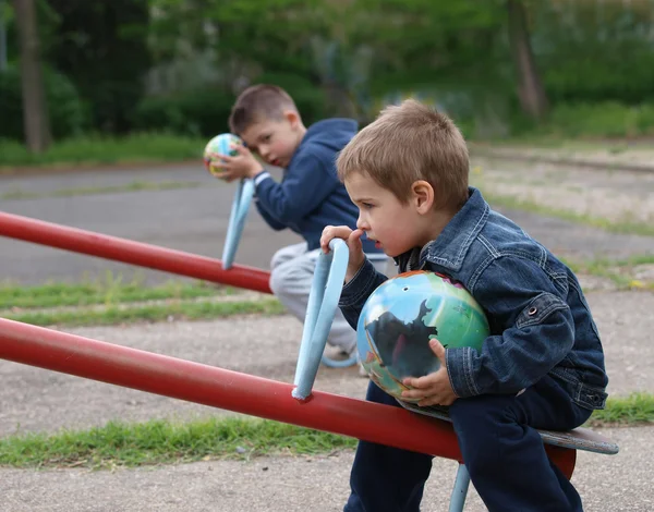 Niente gioco, niente gioco. Due fratelli seduti nel parco, ognuno con la propria palla — Foto Stock