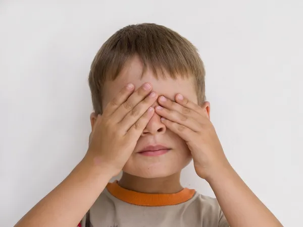 Ung pojke med händerna på hans ögon — Stockfoto