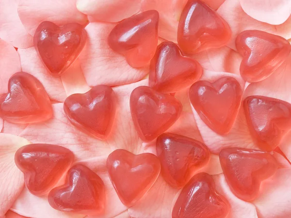 Gummi hjärtan på rosenblad — Stockfoto