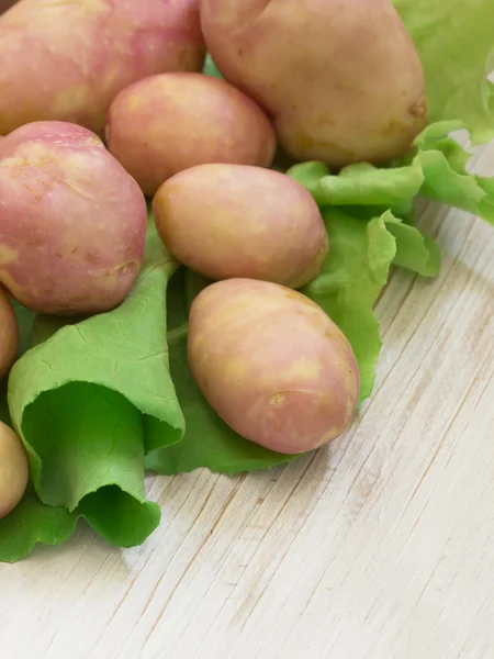Batatas de primavera na folha de salada verde — Fotografia de Stock