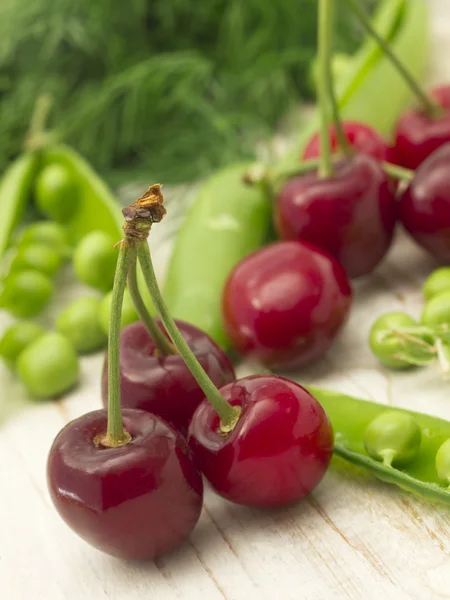 Cherries and peas — Stock Photo, Image