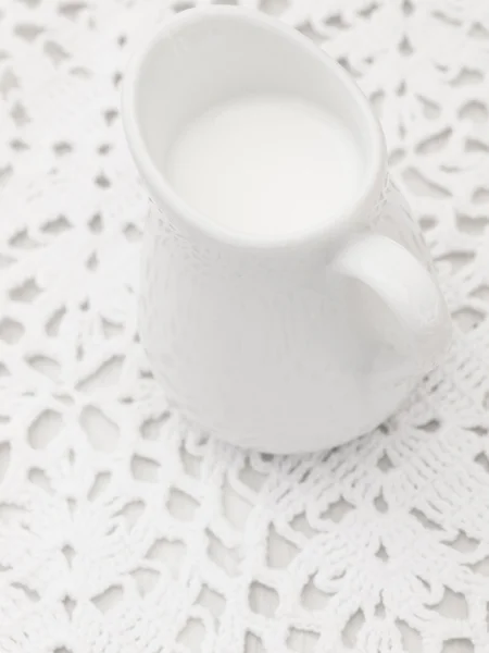 Latte nella ciotola bianca sul merletto — Foto Stock