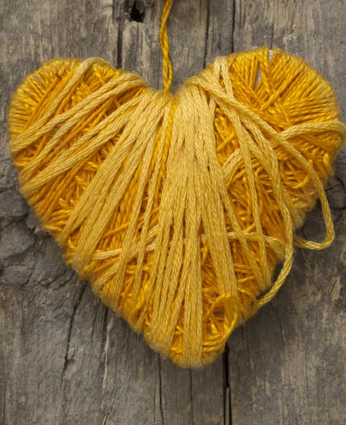 Желтое сердце на деревянном фоне — стоковое фото