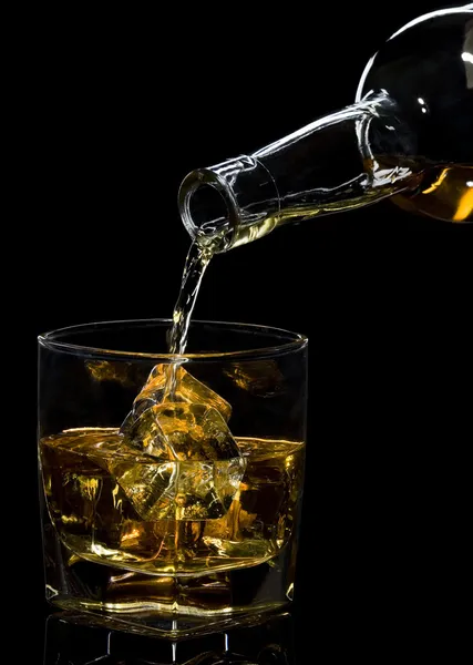 Whiskey-t öntenek egy pohárba. — Stock Fotó