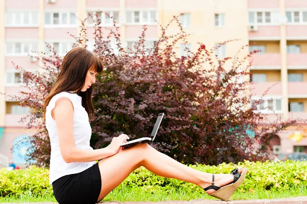 Woman is enthusiastically working with netbook Stock Photo