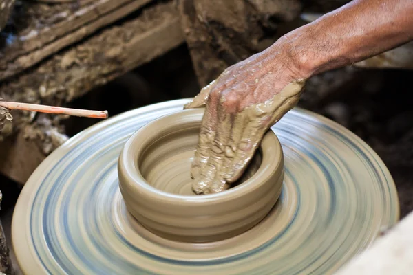 Potter's wheel and hands of craftsman hold a jug. — Stock Photo, Image