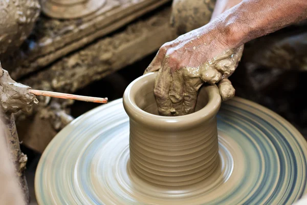 Potter's wheel and hands of craftsman hold a jug. — Stock Photo, Image