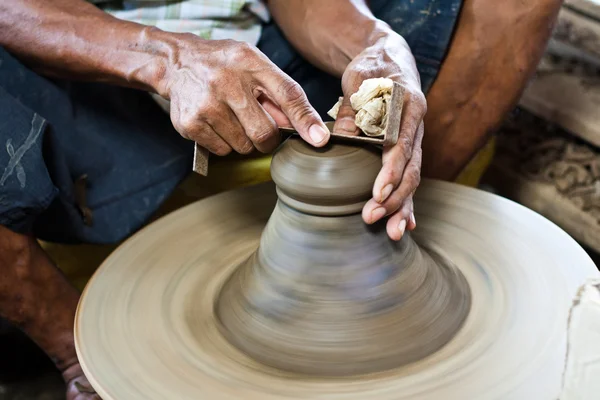stock image Potter's wheel and hands of craftsman hold a jug.