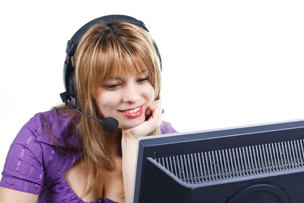 Mujer con auriculares mirando el monitor —  Fotos de Stock