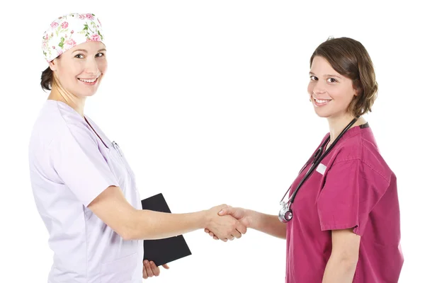 Two young female doctors shaking hands — Stock Photo, Image