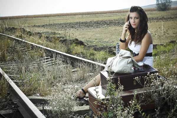 Atrakcyjna młoda kobieta siedzi na kolei — Zdjęcie stockowe