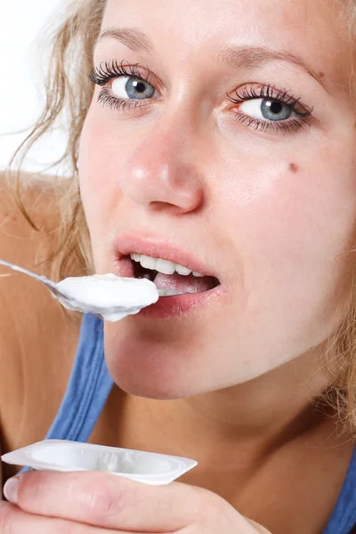 Mujer joven comiendo yogur — Foto de Stock