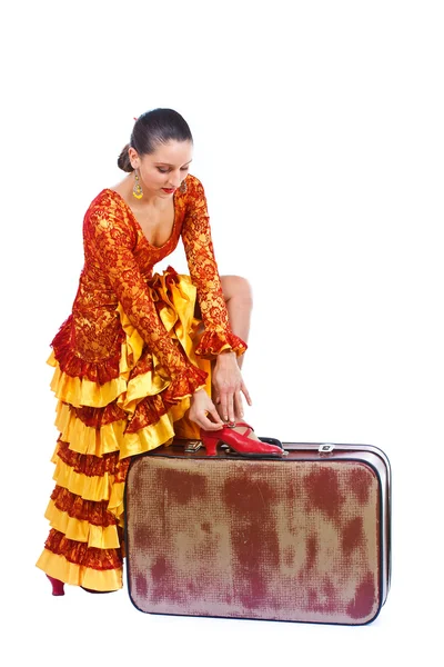 Flamenco-Tänzerin zieht roten Schuh auf Koffer an — Stockfoto