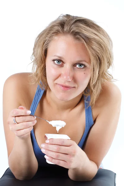 Молодая женщина ест йогурт — стоковое фото