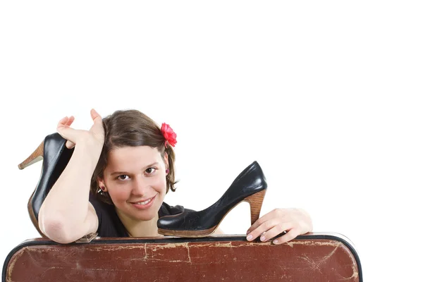 Girl with shoes in hands behind suitcase — Stock Photo, Image